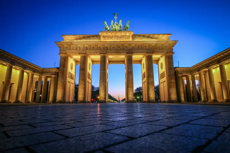 Brandenburger Tor upplyst mot en blå kvällshimmel